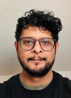 A person with glasses and beardDescription automatically generated