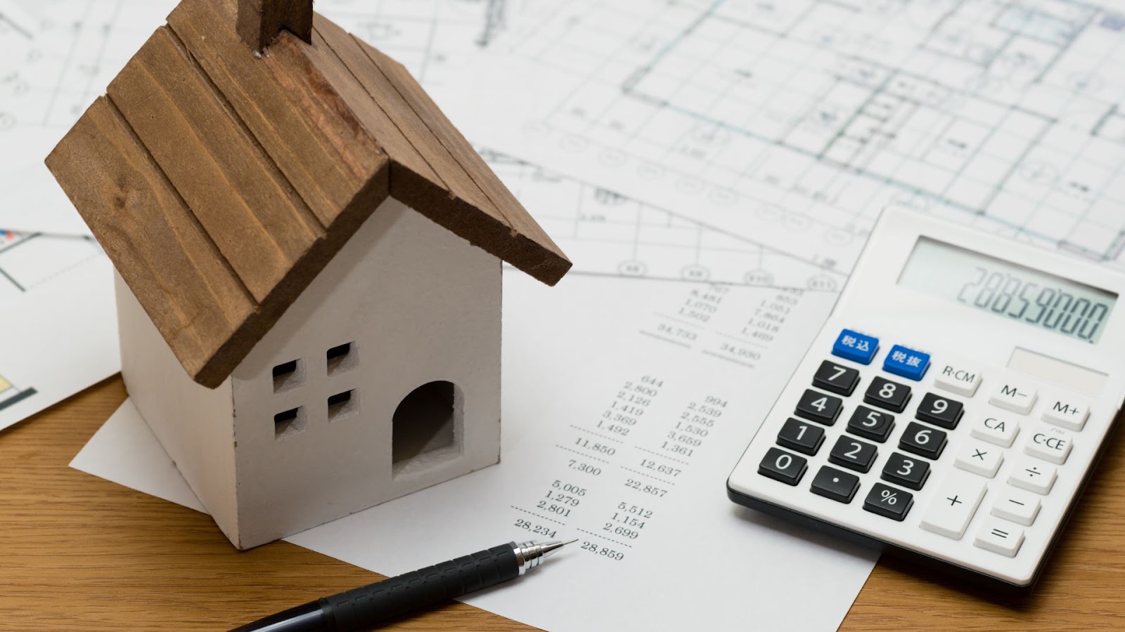  House model, calculator, pen and paper on a table