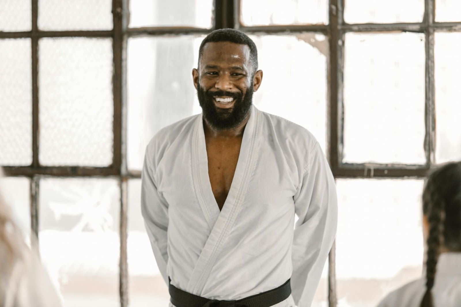 A smiling martial arts instructor addressing his students