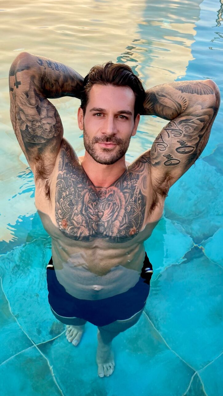 gay xxx onlyfans creator Papi Kocic posing in the pool shirtless with his hands behind his head