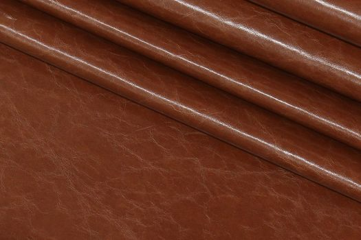 A close-up of a brown shiny leather imitation fabric.