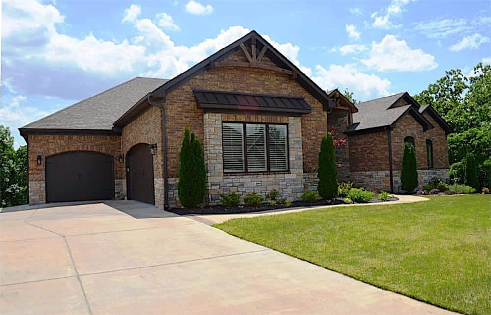 Left exterior view showing the multiple garages enclosed in wooden arched doors.