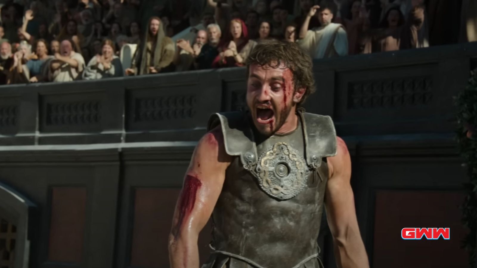 A bloodied Lucius screams triumphantly in front of an audience.