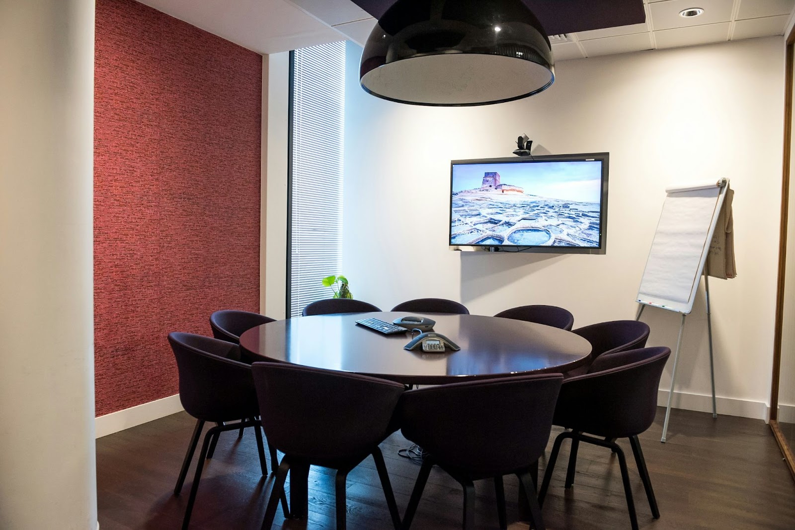 A wall-mounted TV in a smaller conference room