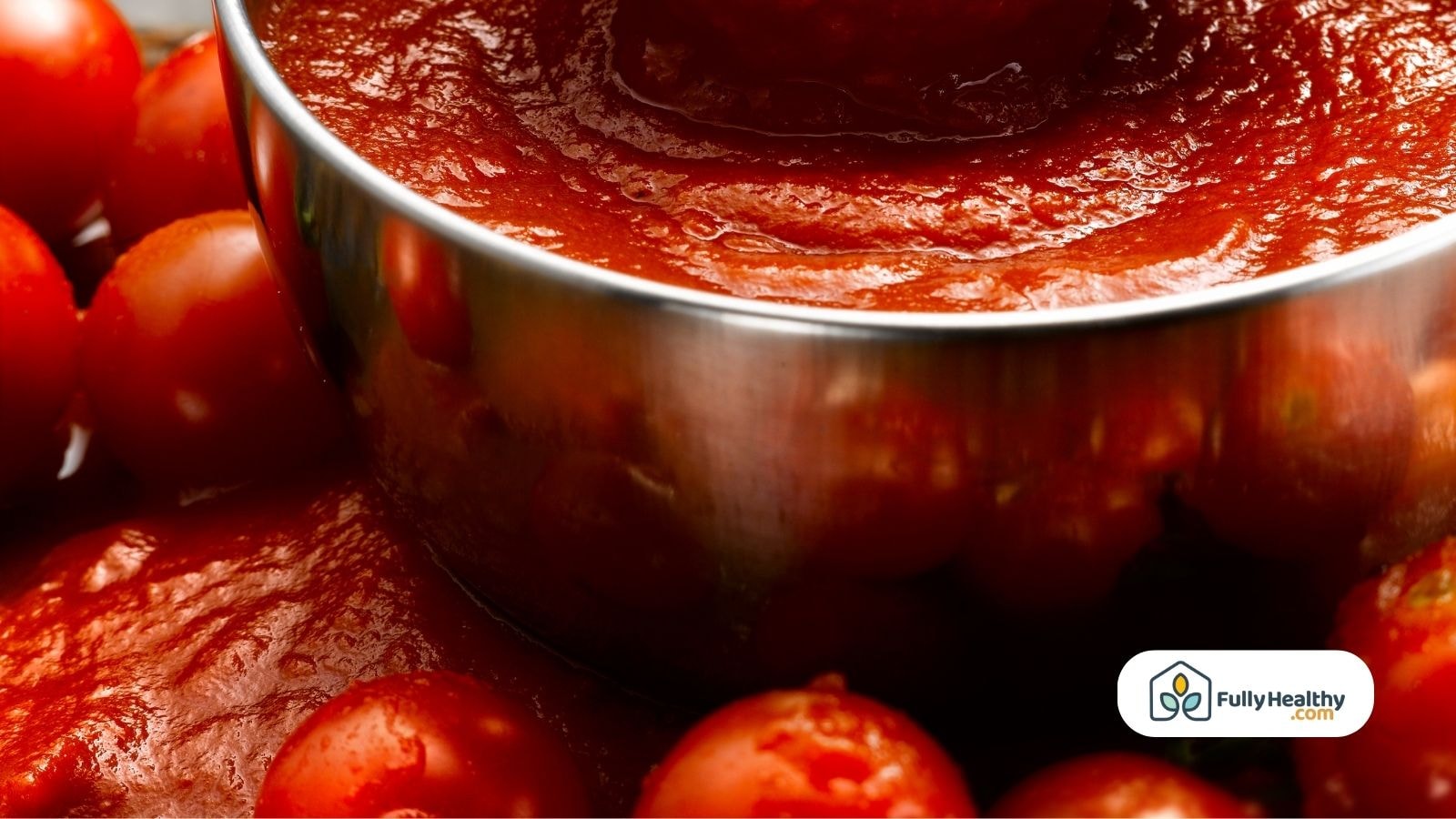 Close-up of tomato sauce in metal pot with fresh tomatoes around