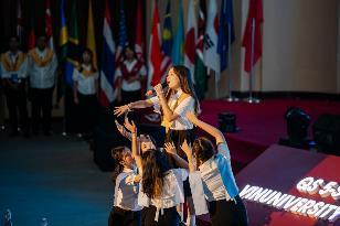 A group of girls on a stage with a microphone

Description automatically generated