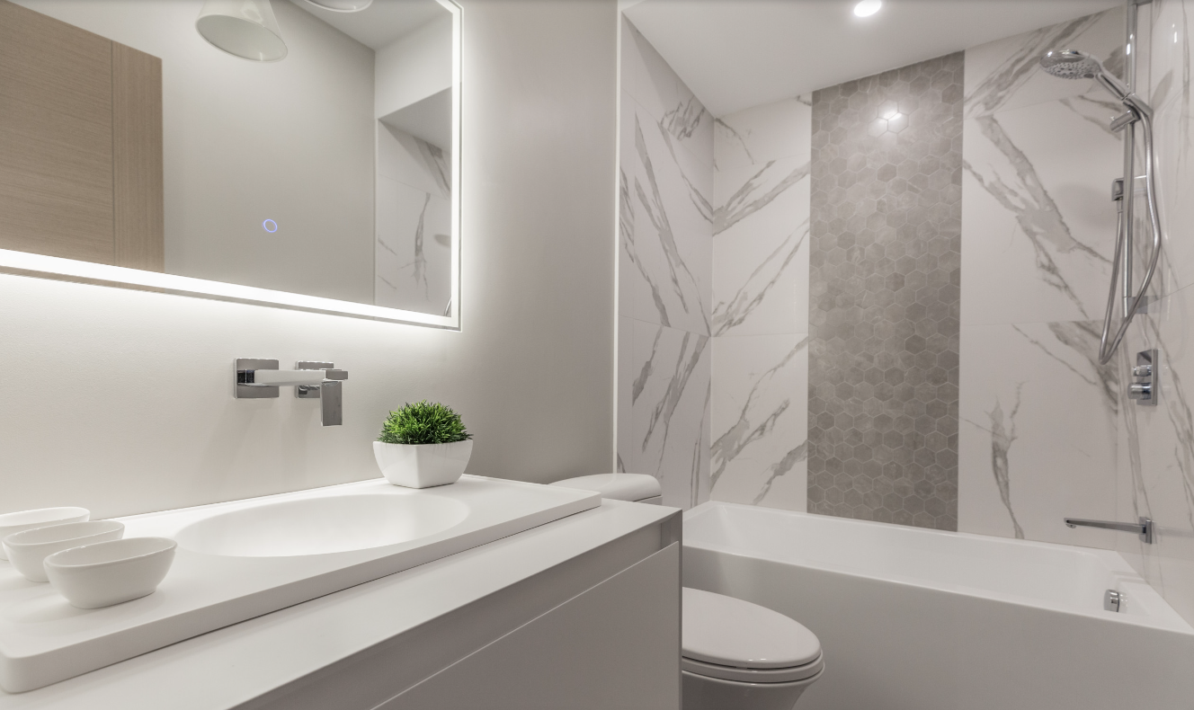 Small modern bathroom with marble accents and wall-mounted fixtures.