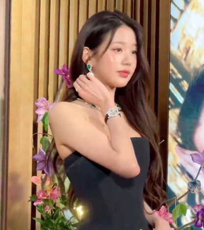 This is a picture of IVE's Wonyoung  in a black dress and her hand on her neck