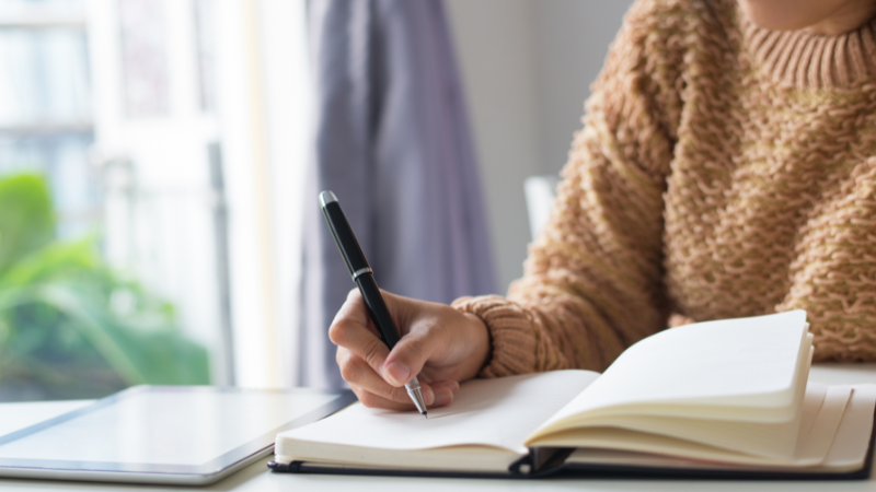 A person writing in a notebook
