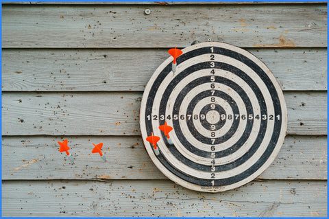 Black and white target with thrown darts