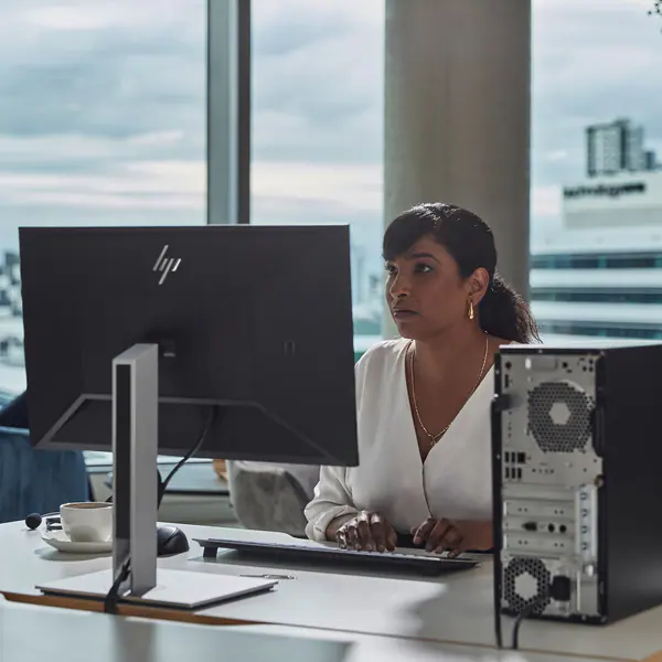 A person sitting at a desk with a computer

Description automatically generated