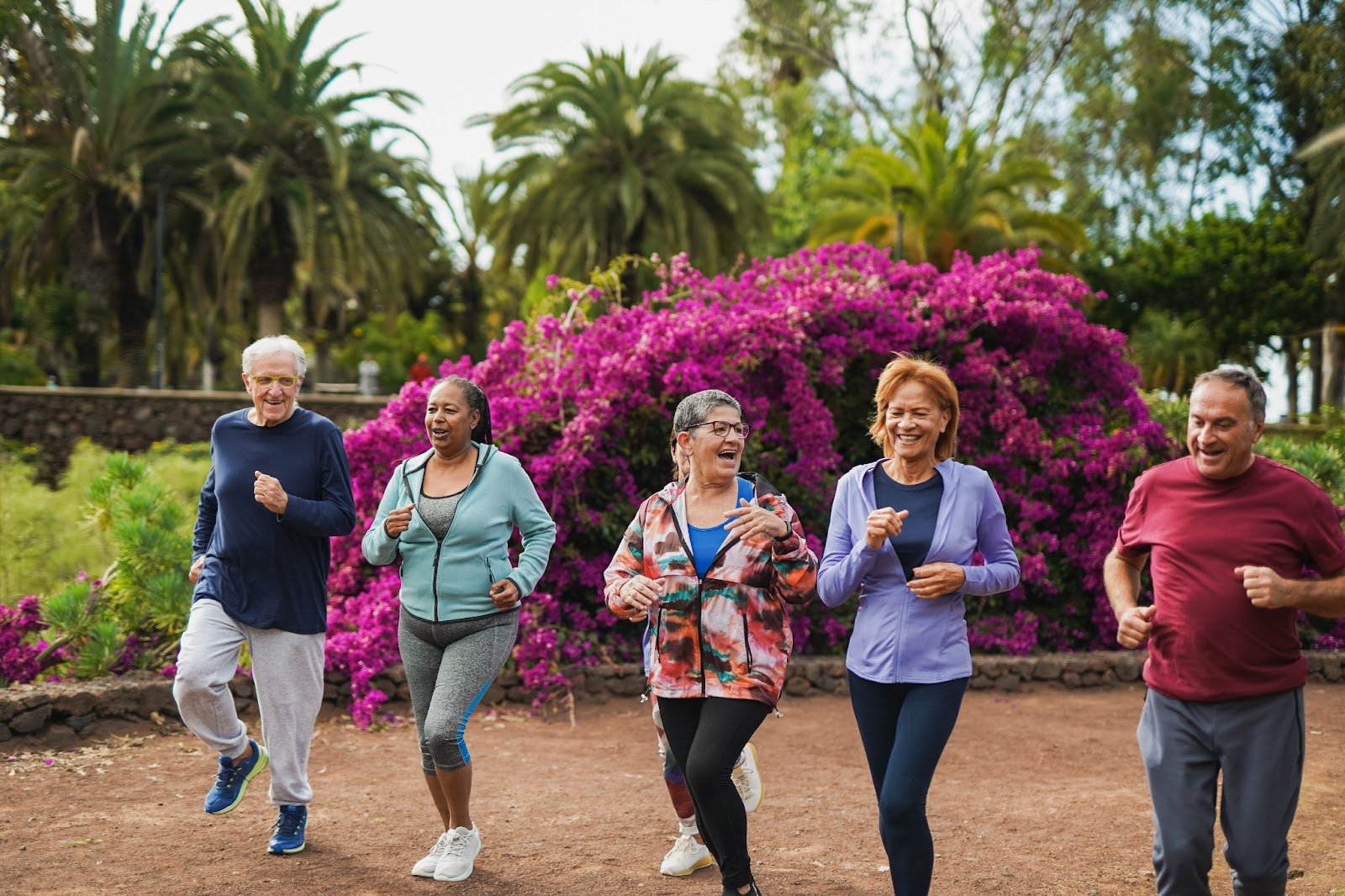 A group of older adults jogging together outdoors.