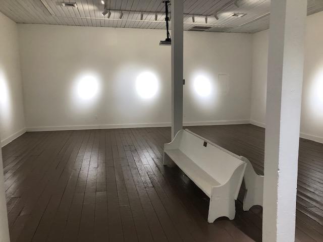 A white bench in a room with a wood floor and ceiling AI-generated content may be incorrect.