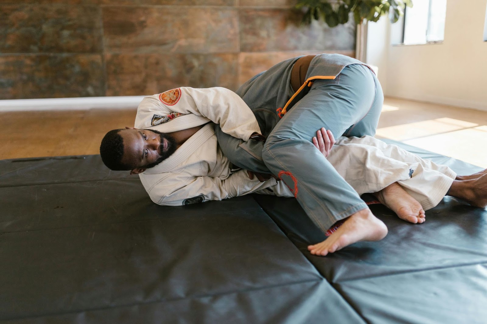 Two martial arts students grappling on the ground