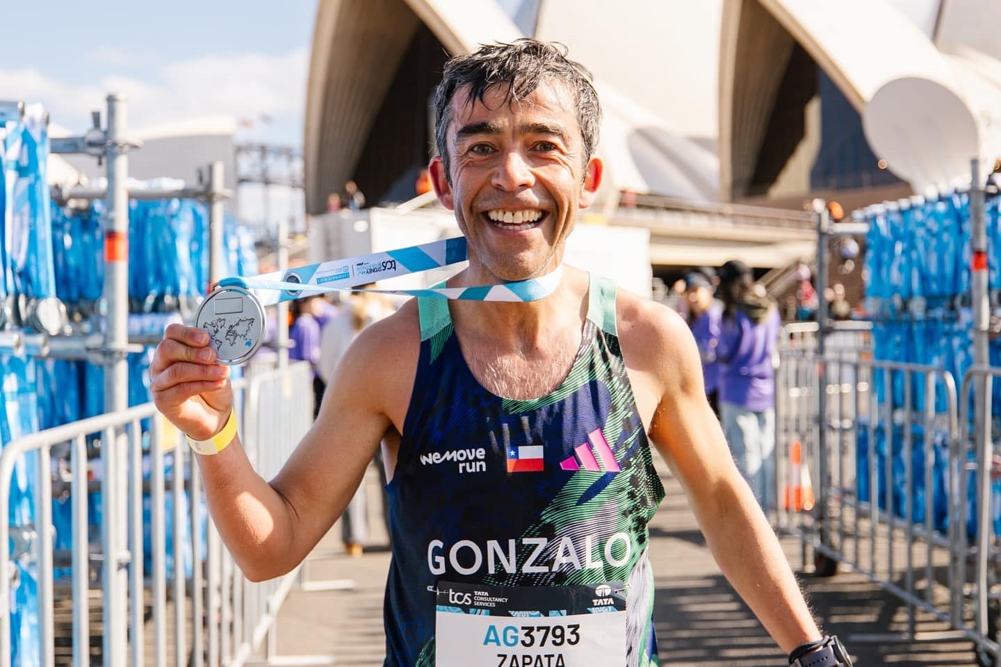 Runner holds a custom Sydney Marathon medal.