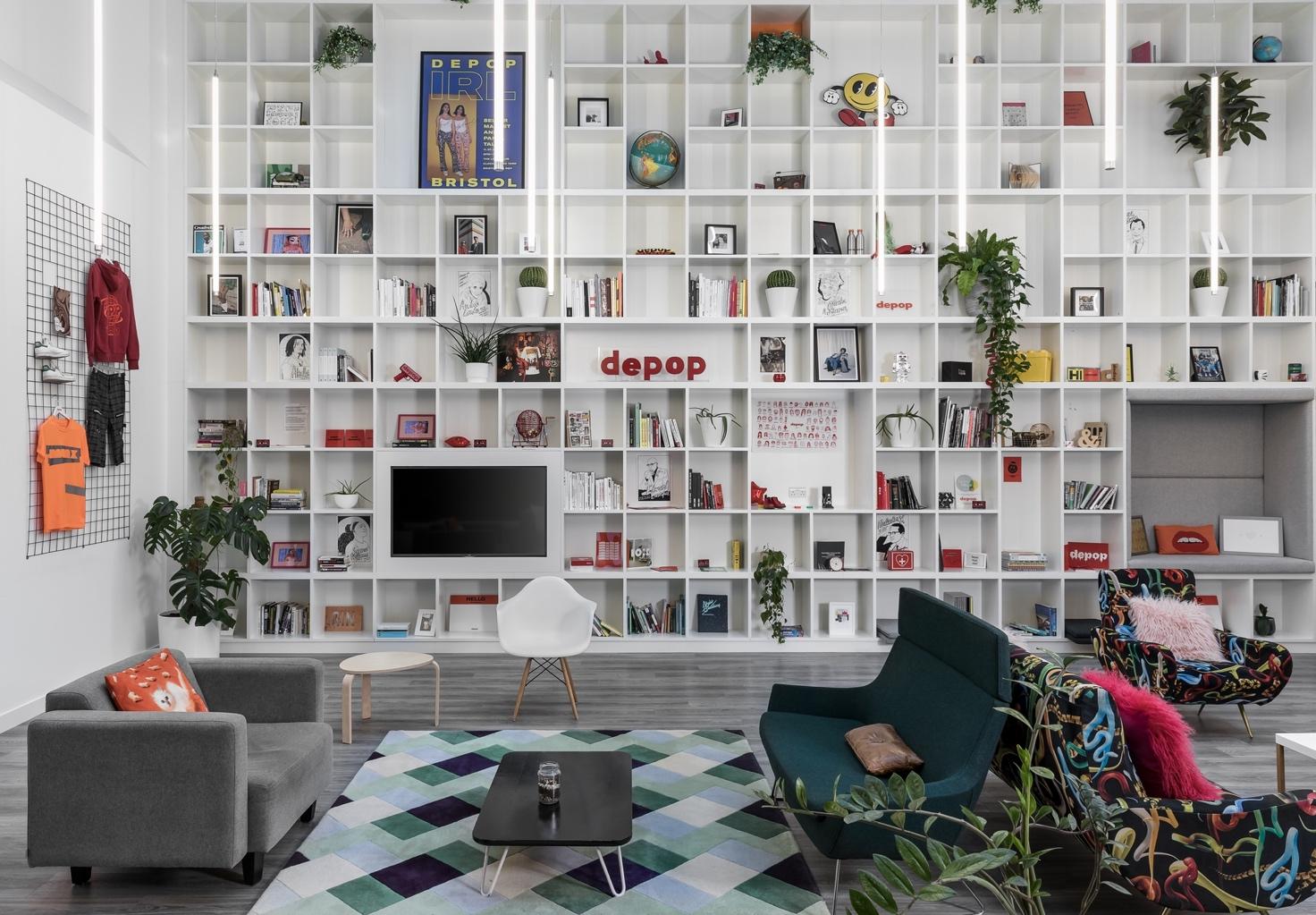 A room with a white wall and shelves full of books Description automatically generated