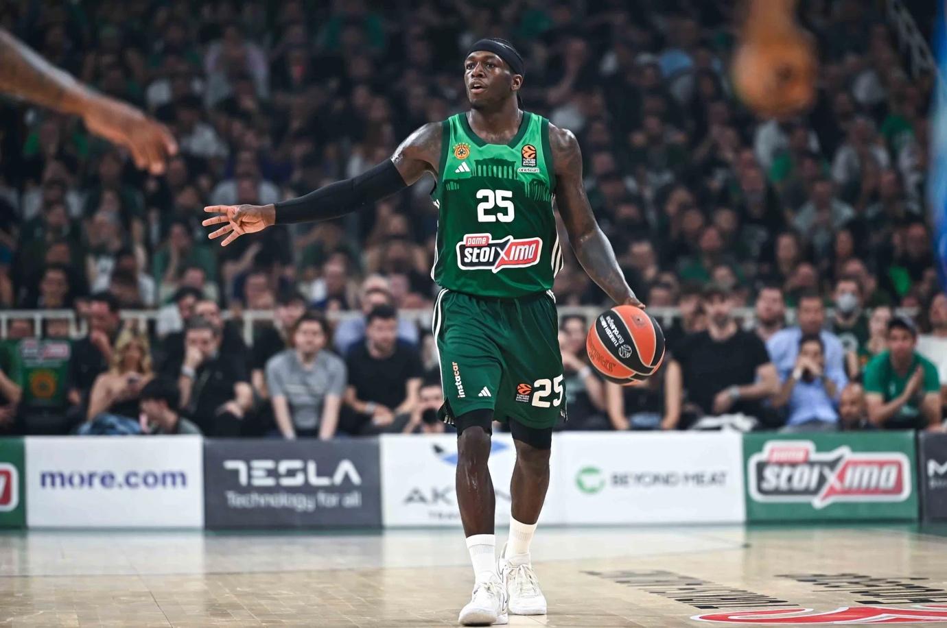 A basketball player in a green uniform with a ball in his hand

AI-generated content may be incorrect.