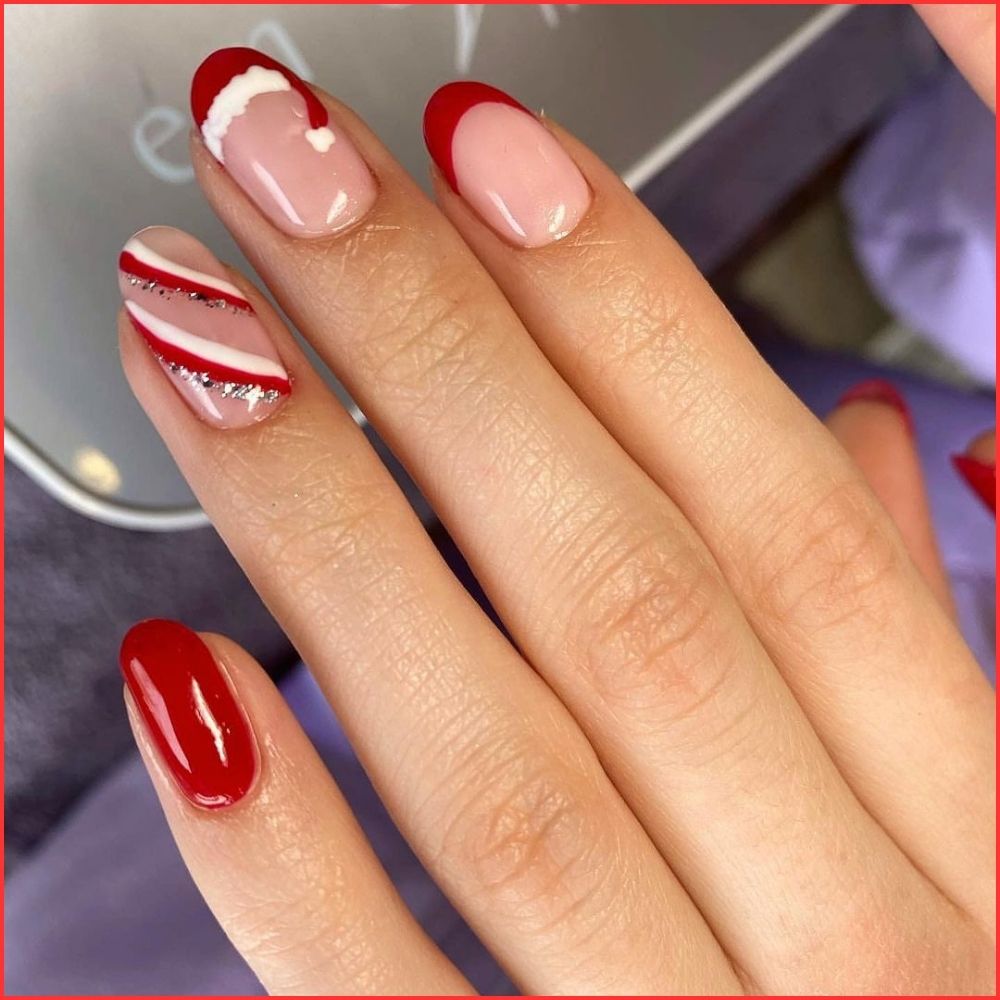 Close up of hands having Christmas red nails with Santa Hat Tip Nails