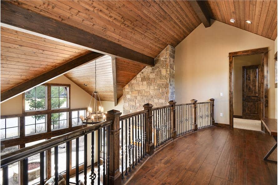 Second-floor balcony with hardwood flooring and wrought iron railings.