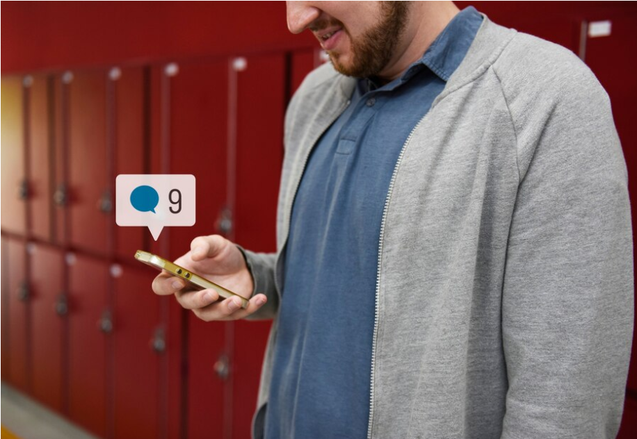 A man checking his phone with a “9 messages” notification on Google Chat