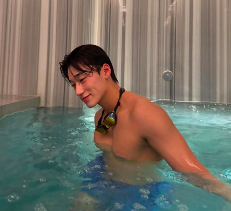 This contains an image of ATEEZ's San in a swimming pool