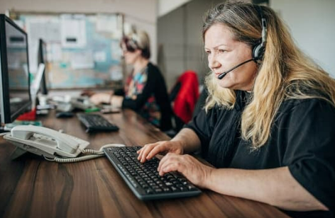 Plumbing dispatcher wearing a headset in front of a computer