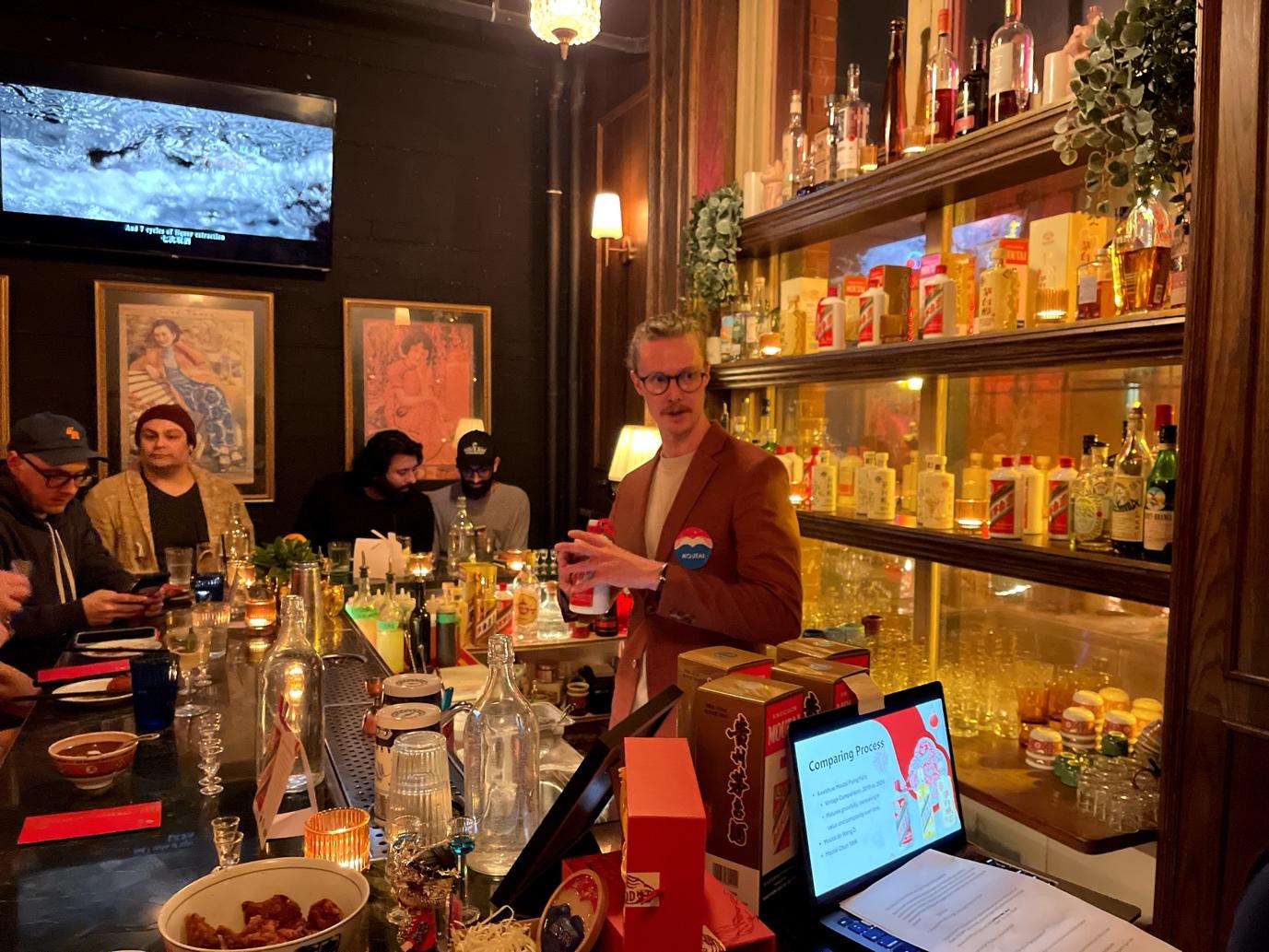 A person standing behind a bar with bottles of alcohol

AI-generated content may be incorrect.