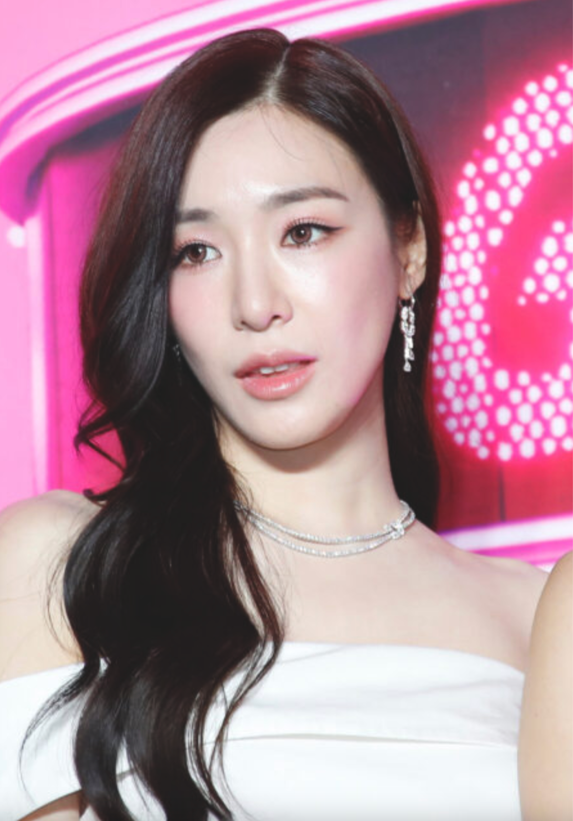 A photo of Tiffany wearing a white gown and wearing a silver neckless 