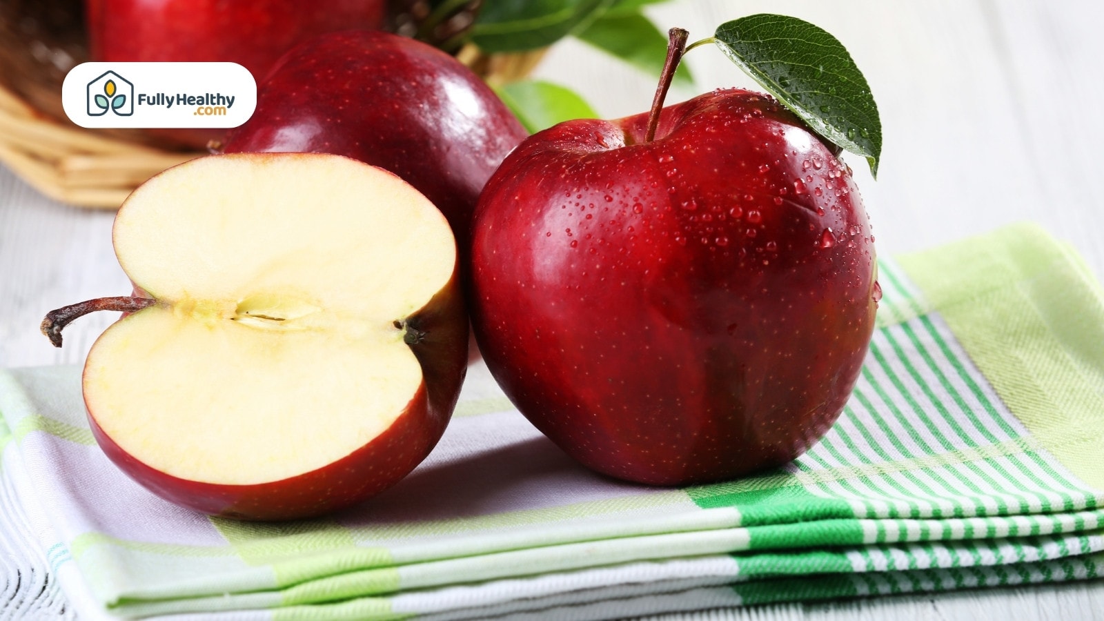 Fresh red apples with a sliced apple on green napkin