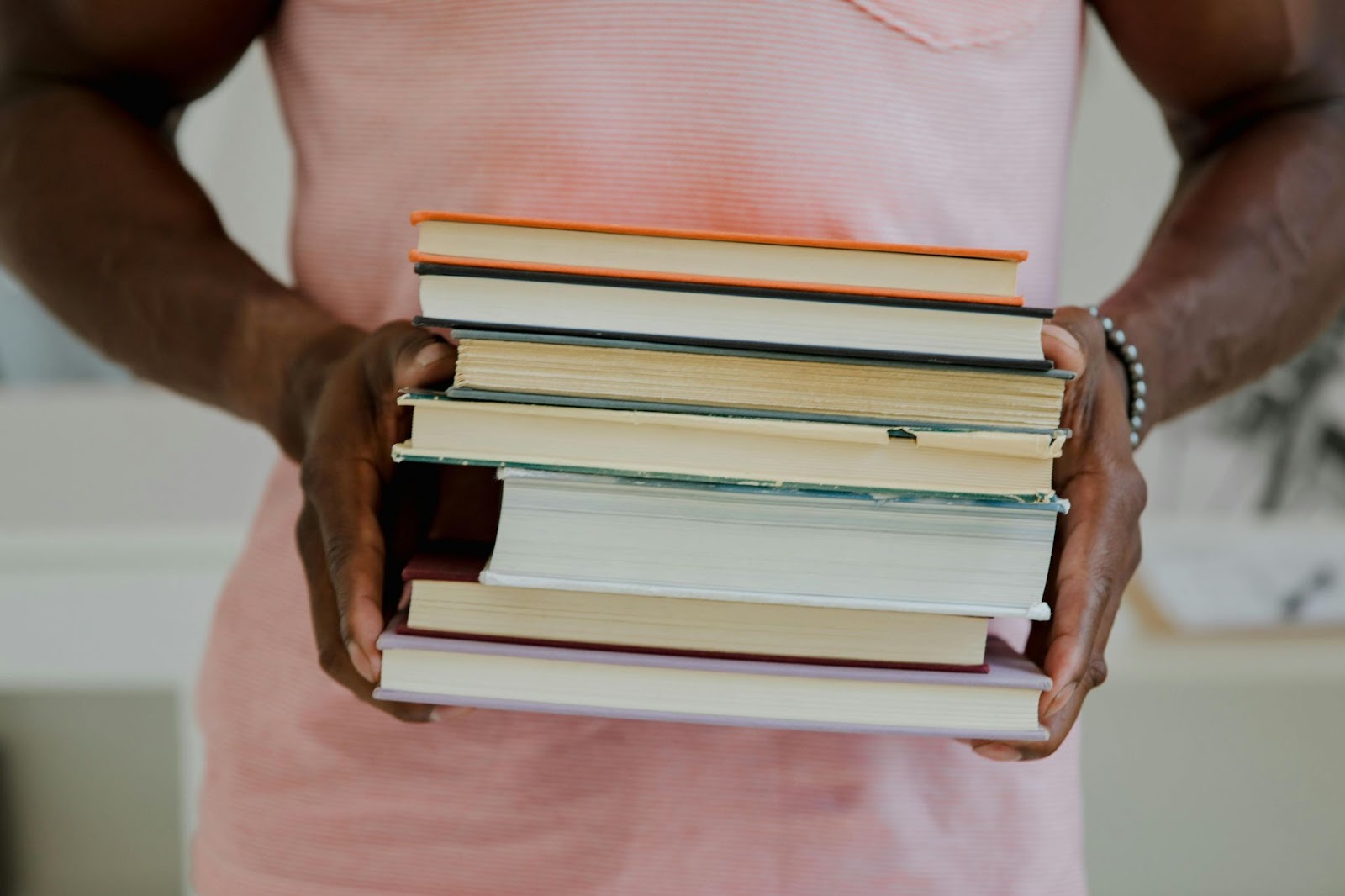 College graduate holding a stack of textbooks. Store books safely at our family-owned Mid-Florida storage facilities with drive-up access and a customer-centric approach
