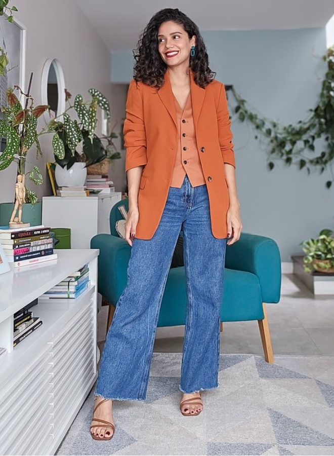 Wanita dengan pakaian oranye dan denim.