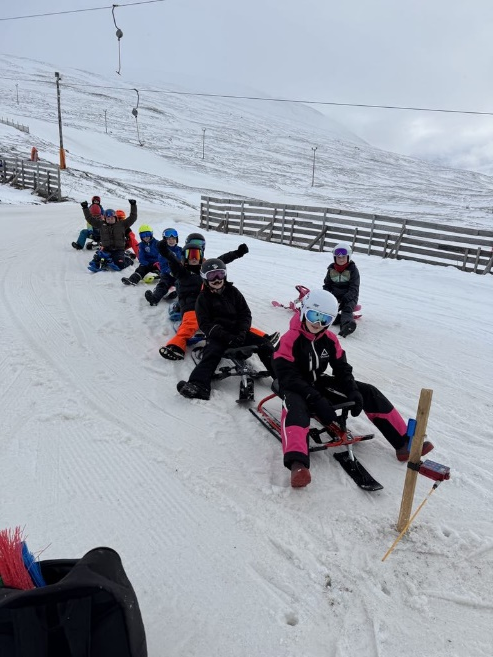 A group of people on sleds in the snow
AI-generated content may be incorrect.