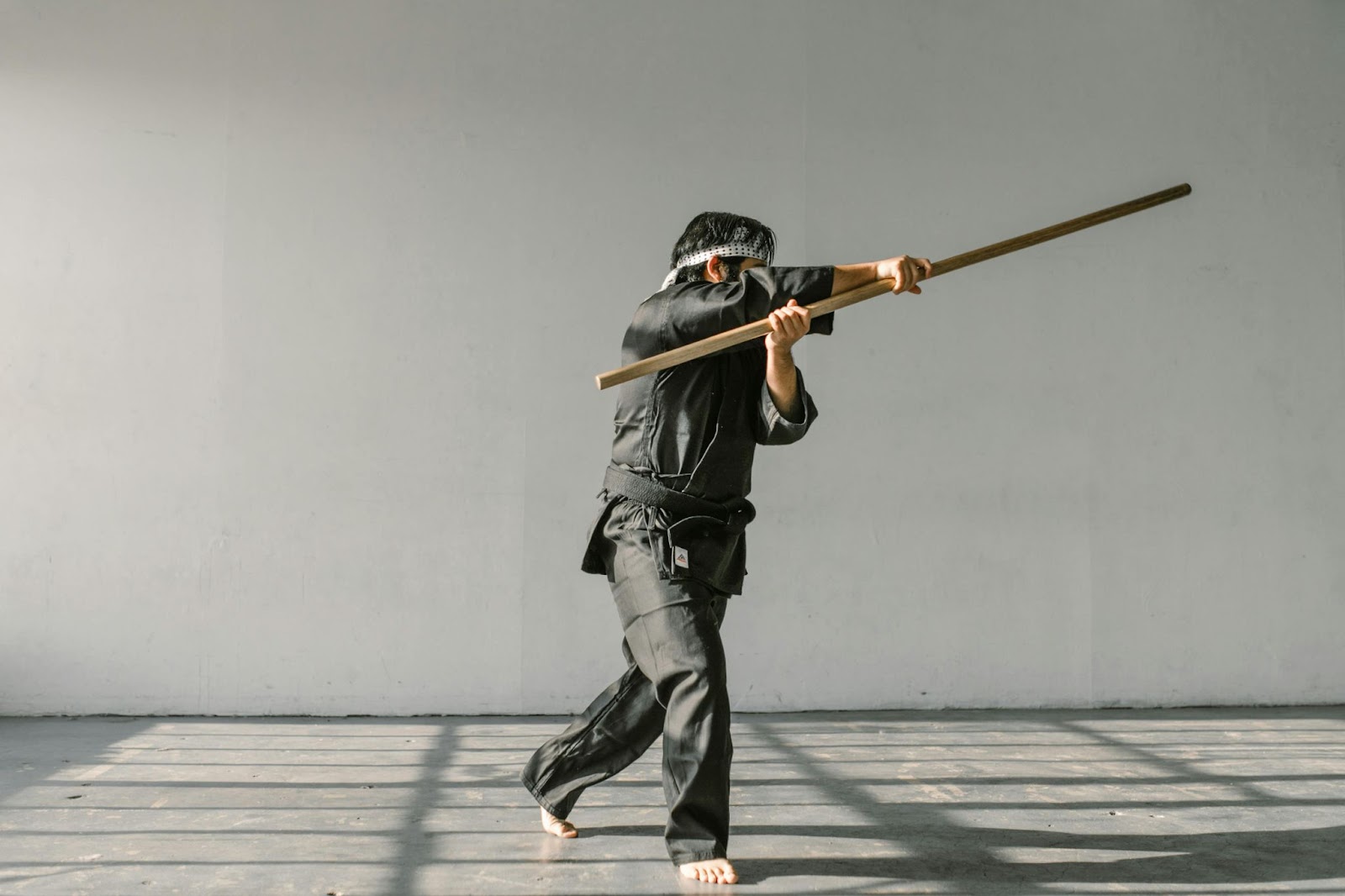 A martial arts instructor performs dynamic moves with a fighting stick during a demonstration