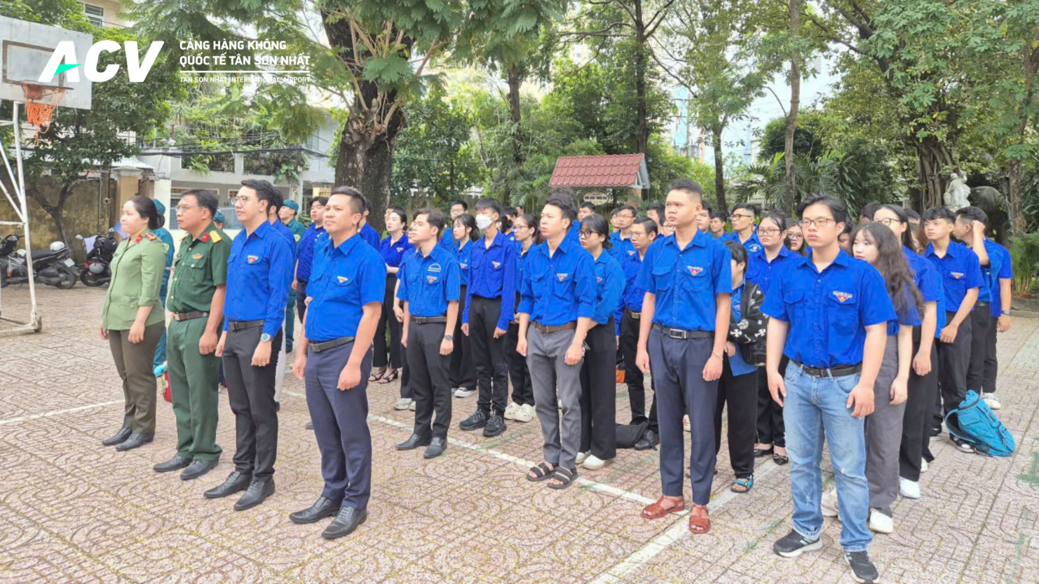 A group of people in blue shirts standing in a lineDescription automatically generated