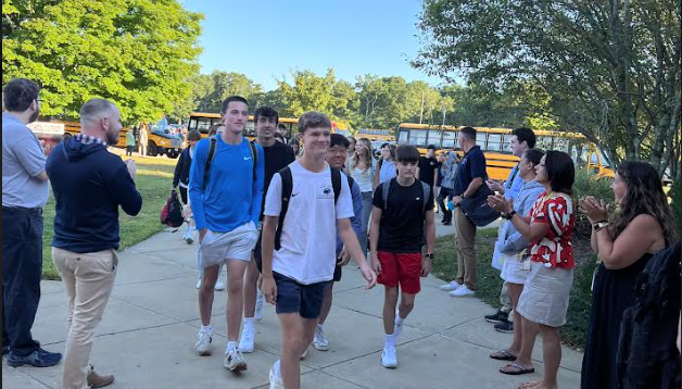 image of staff greeting students on the first day of school