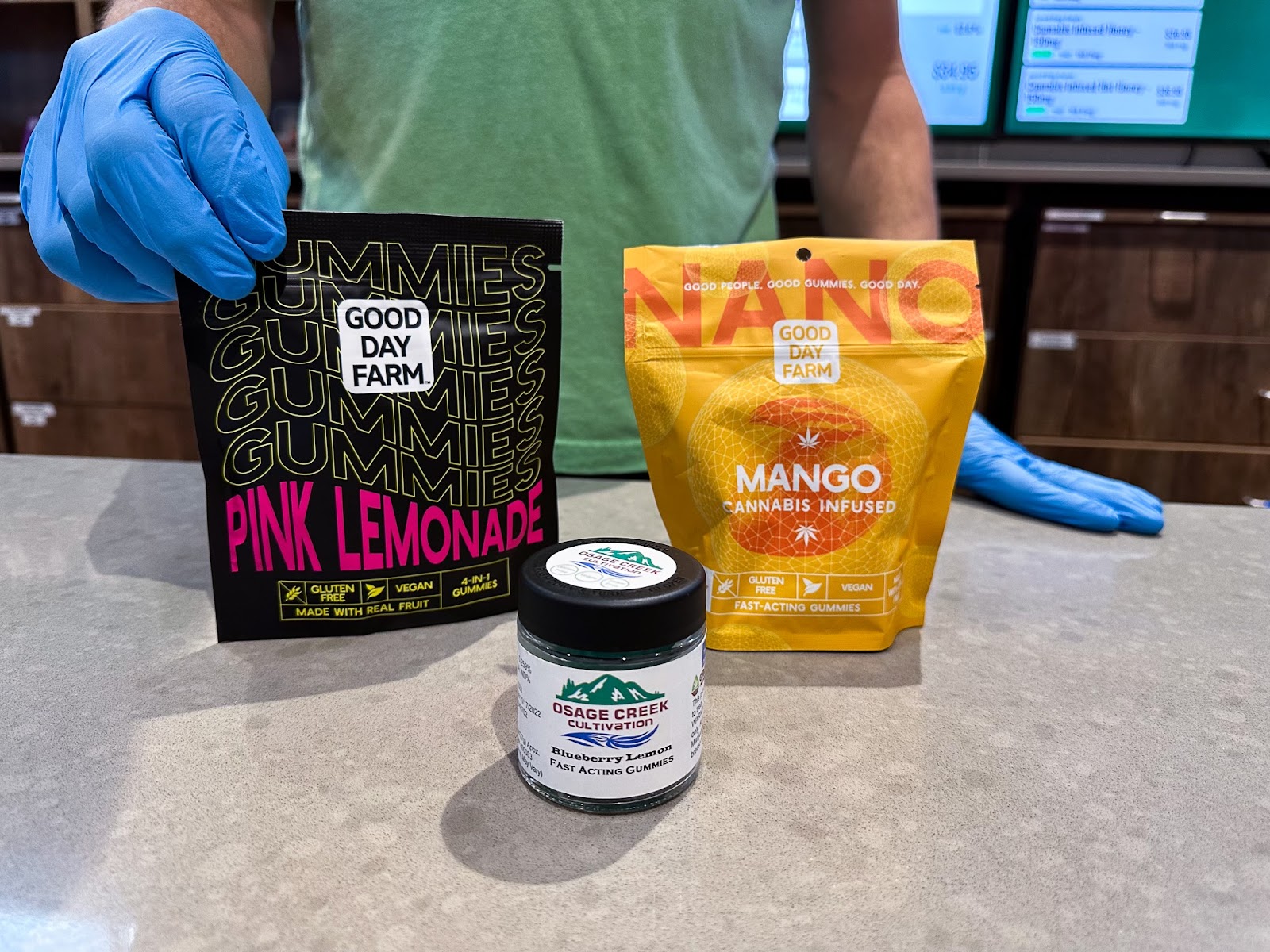 Shaun Forrester, a budtender at The Source cannabis dispensary in Rogers, Arkansas, displays Good Day Farms multi-dose gummies, NANO fast-acting cannabis-infused gummies, and Osage Creek fast-acting gummies available for purchase in-store or through The Source online shop.