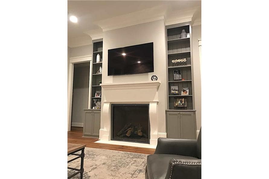 The living room features a fireplace and wall-mounted TV flanked by gray built-ins.
