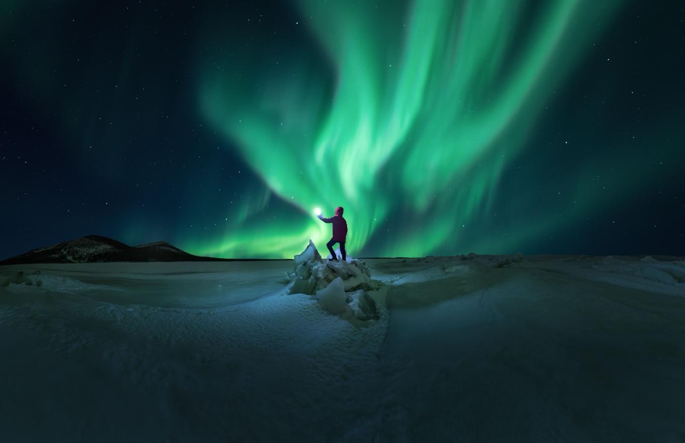 Green Glow of the Northern Lights Over a Snowy Landscape | Skylum Blog