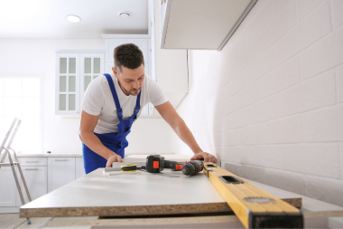 reasons it is challenging to compare remodeling contractor bids upfront remodeler measuring new countertops in kitchen remodel custom built michigan