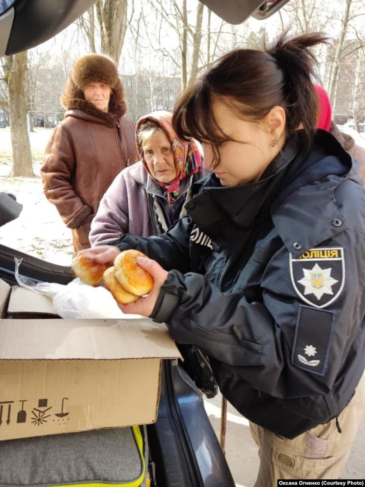 A police officer holding food

Description automatically generated