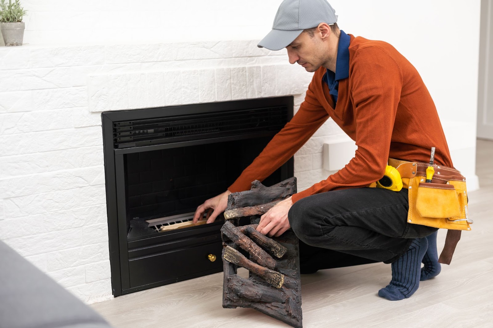 A professional technician installs an electric fireplace in a modern living room.