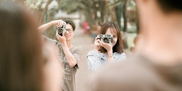 A student couple take pictures to show the concept of a supportive environment for mental health