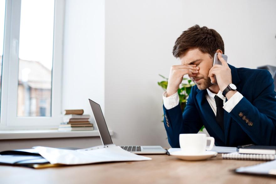 A businessman frustrated while talking on the phone.