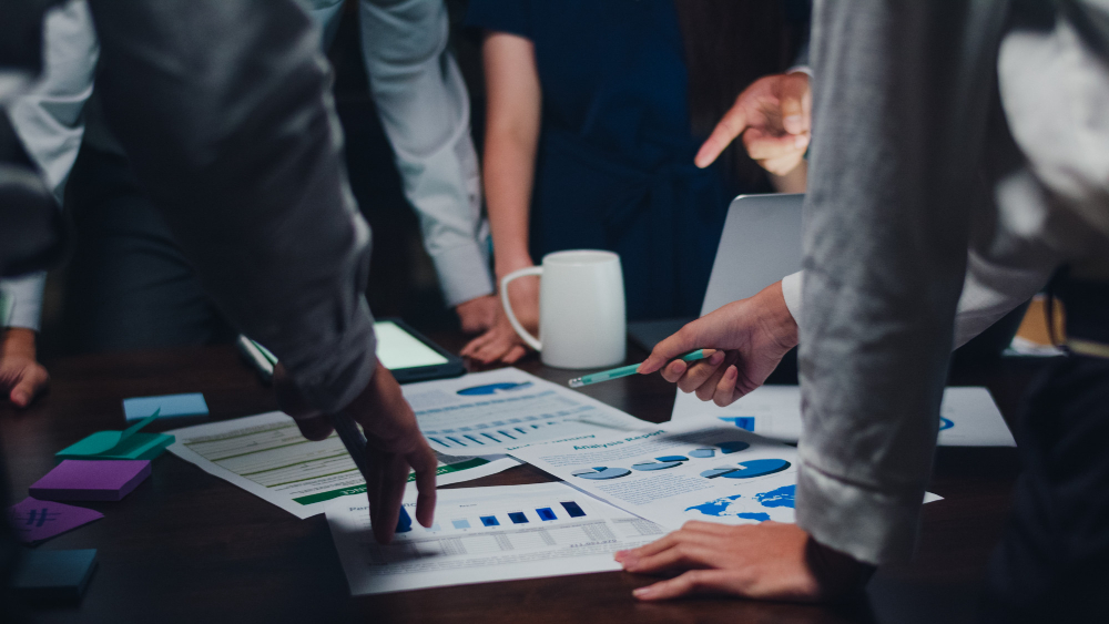 Close-up of a business team reviewing financial charts, data reports, and graphs during a strategy meeting, highlighting collaborative enterprise planning.
