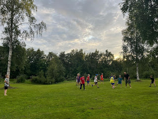 A group of kids running on a grass field Description automatically generated