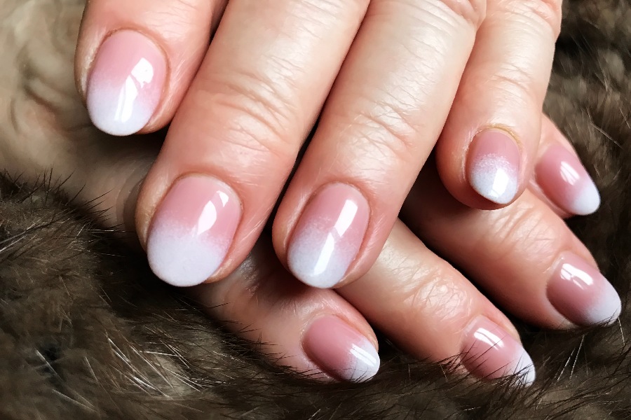 Ombré fade blends colors seamlessly for a soft, elegant French nail tip design.