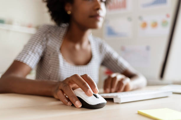 Woman clicking a computer mouse, illustrating clickbait headline psychology in action at the moment of decision.