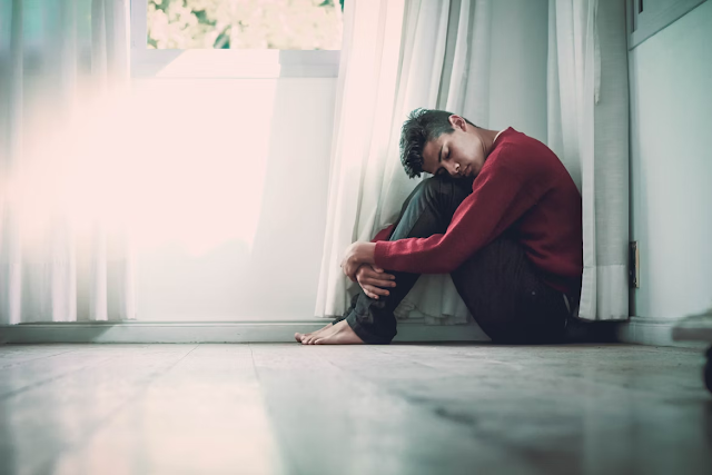 man looking sad hands on legs in bathroom