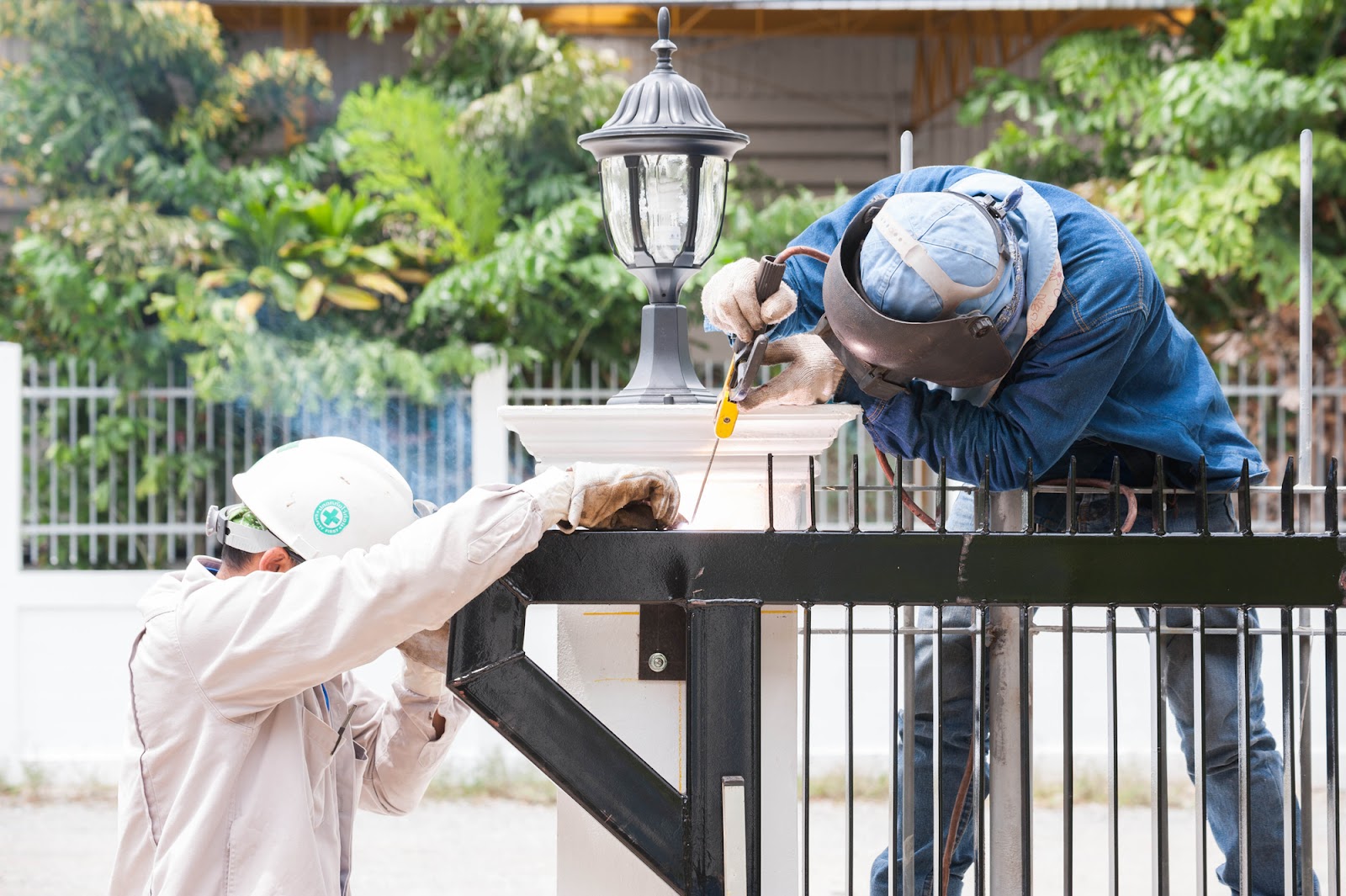 Welder repairing the metal fence