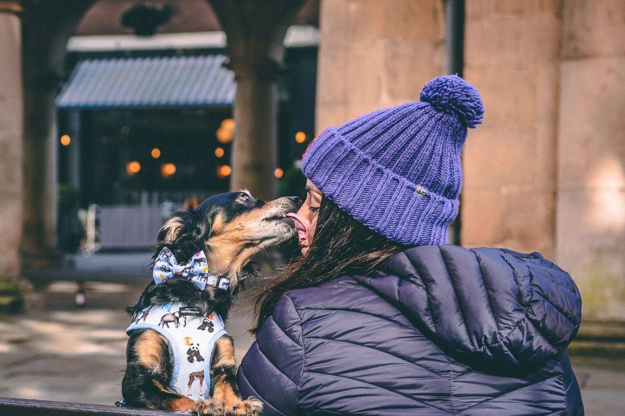 Rachel getting kisses off her small black and tan dog Rico